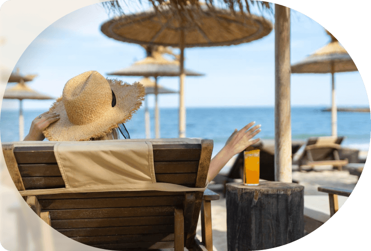Ξαπλώστρα σε beach bar με χυμό, θάλασσα και ομπρέλες